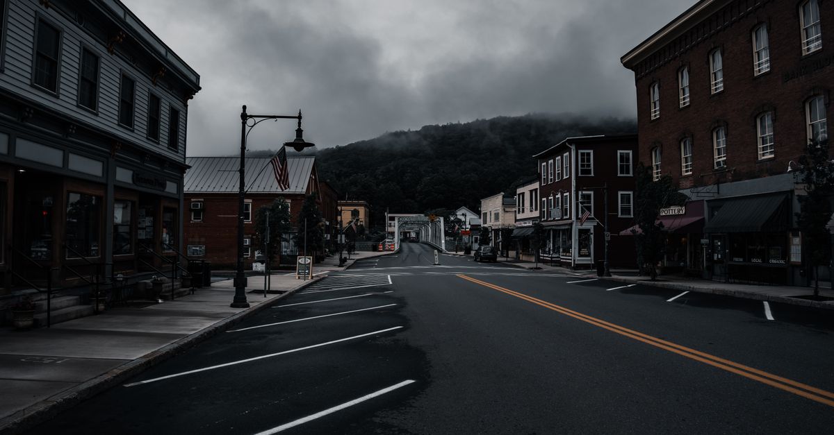 Empty town street with historic buildings and moody clouds. Perfect for travel or urban exploration themes.